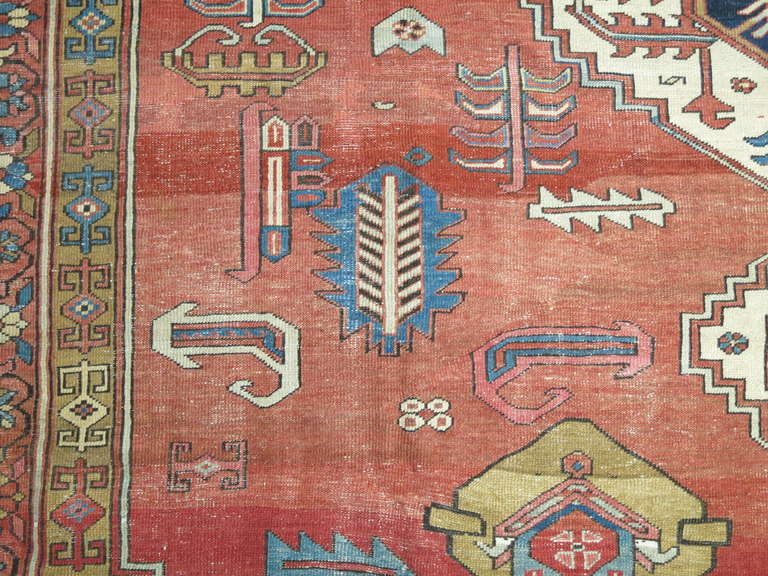 A classical antique Bakshaish rug containing a tribal geometric design with rustic color accents.

Measures: 12' x 17'8