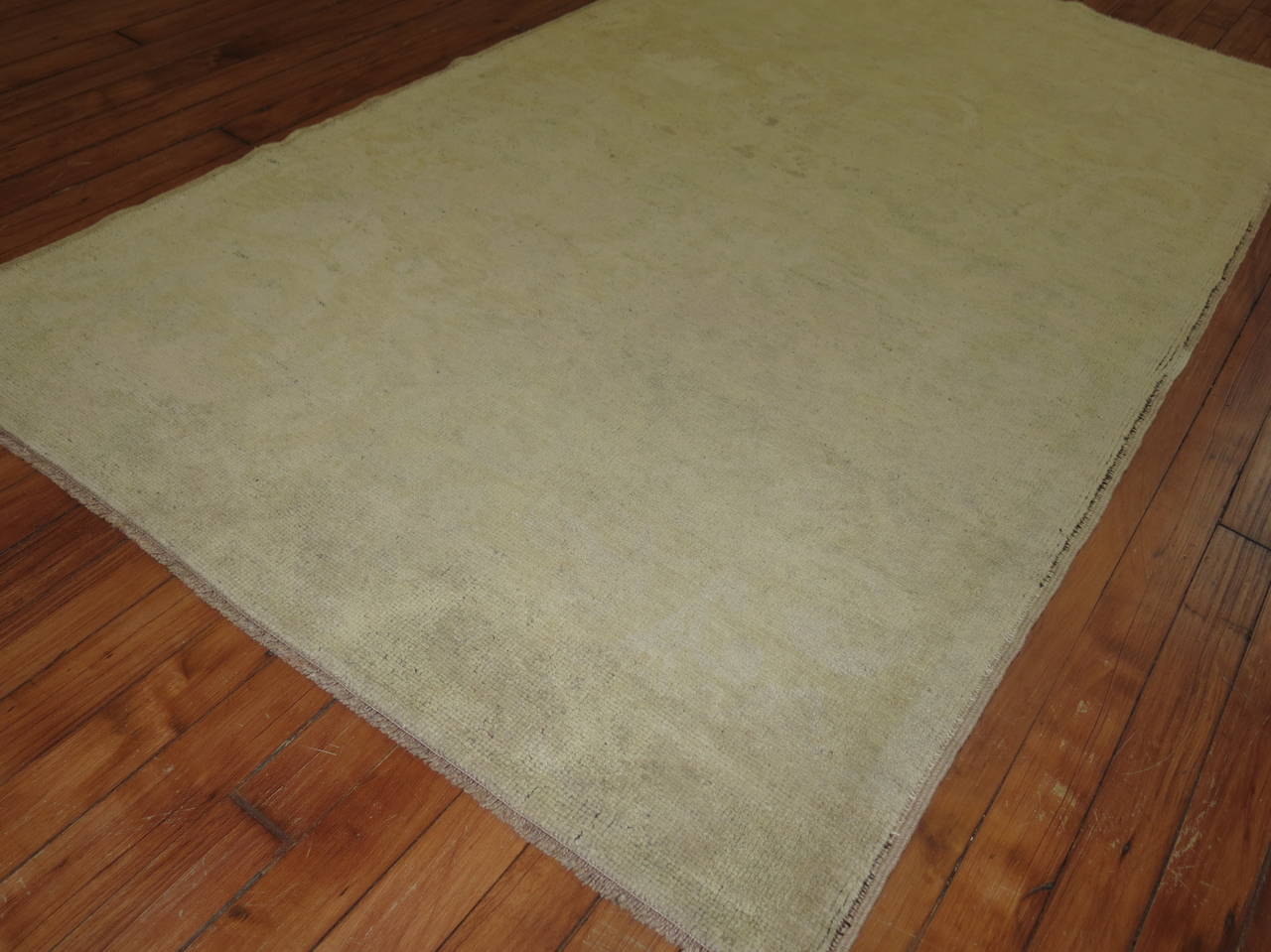 A sublimed Turkish Oushak with an elegant floral motif. The motif can barely be seen. Colors are a pale yellow green and brown

3'3'' x 5'7''