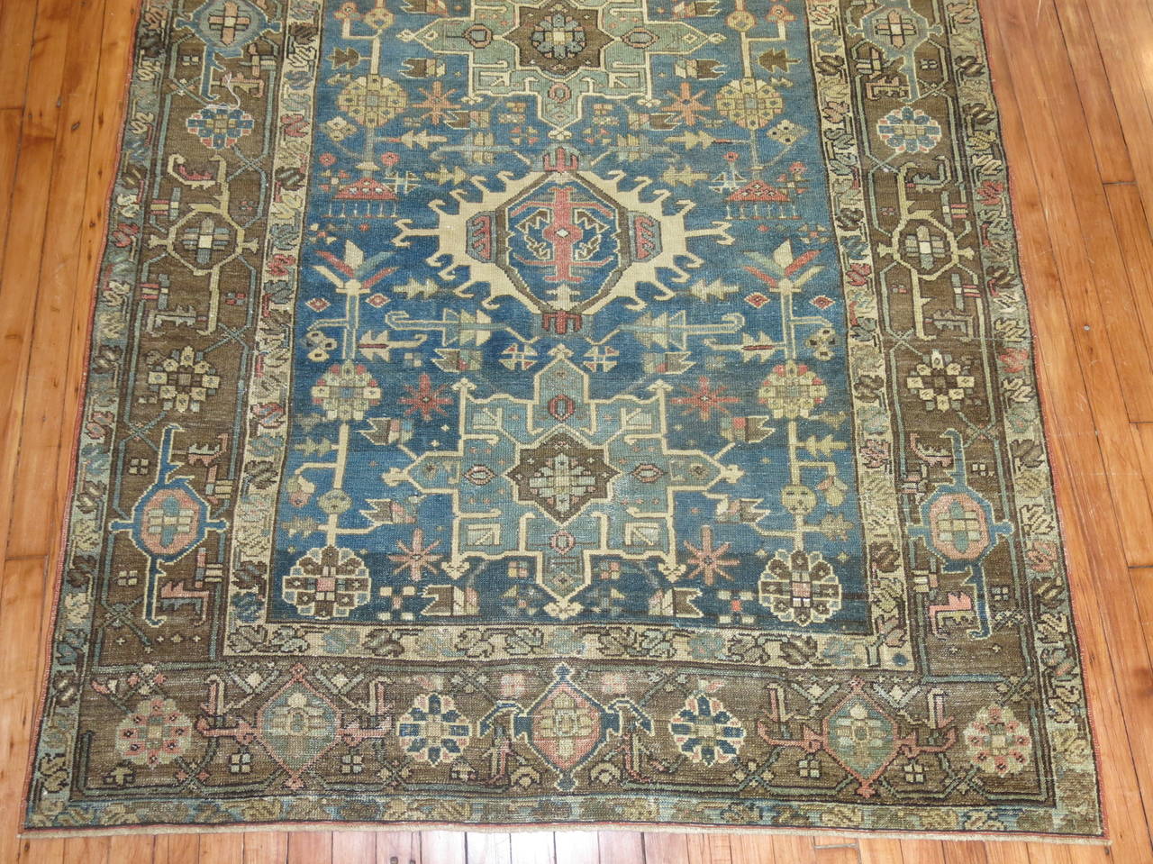 Square size Persian heriz rug with an ocean blue field and camel border.

Heriz carpets are beloved for their versatility. Their geometry complements modern furnishings and their warm colors and artistic depth enhance antiques of all kinds. Their