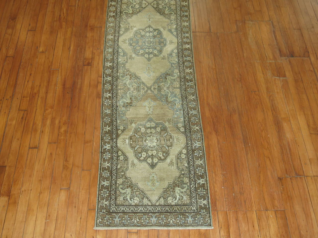 A narrow and long Persian Tabriz runner in browns and caramel.