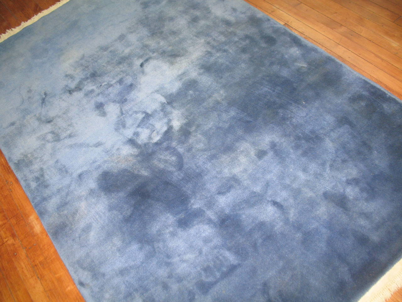 A Vintage Chinese rug with a plain solid blue field.