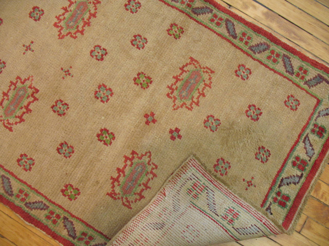 A 1920s Turkish Oushak runner with an all-over motif on a camel field surrounded by thin multiband border. Accents in red, blue gray and green.

Measures: 2'10