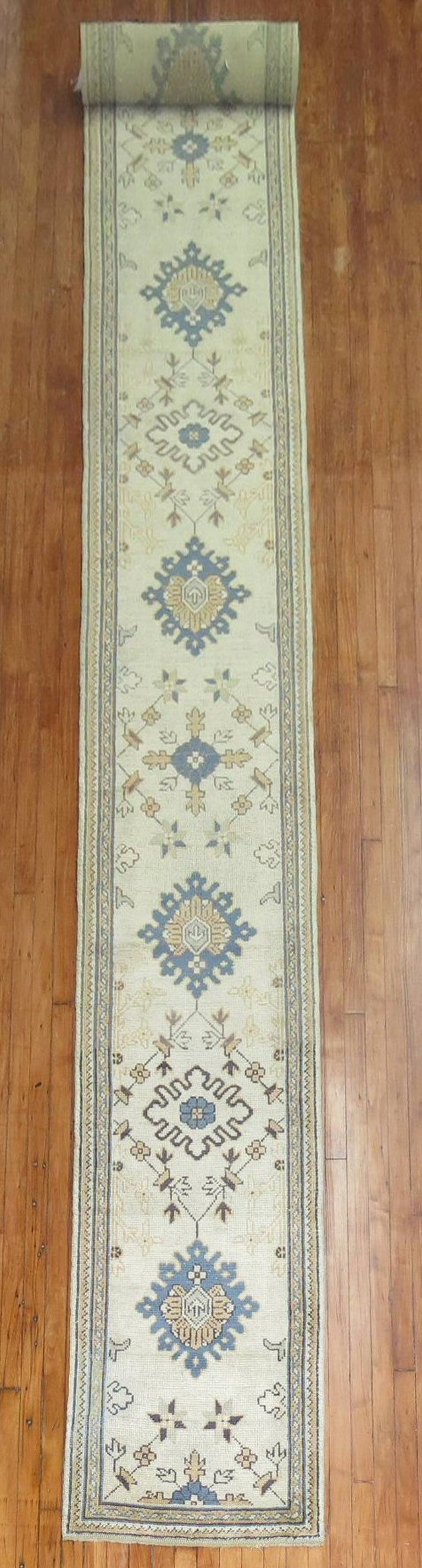 A long and narrow rare size early 20th century antique Oushak runner. Accents in blue, goldenrod soft green accents,

circa 1900-1910. Measures: 2'3'' x 22'4'.