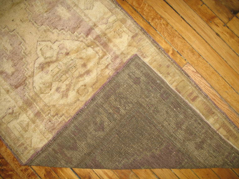 A narrow vintage Turkish Oushak runner in lavender and pale gold.
