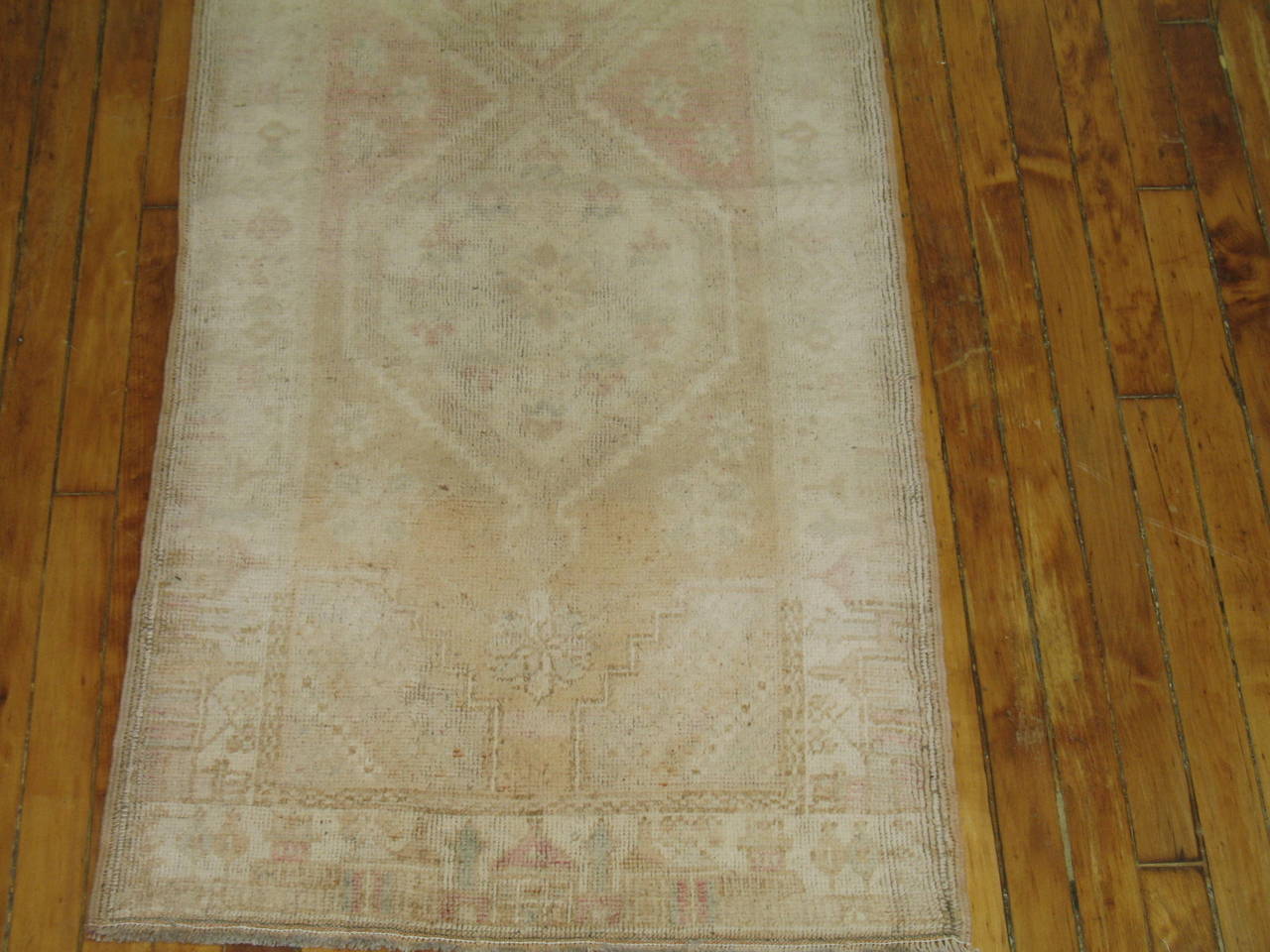 Turkish Oushak narrow runner in faded creams and soft pinks.