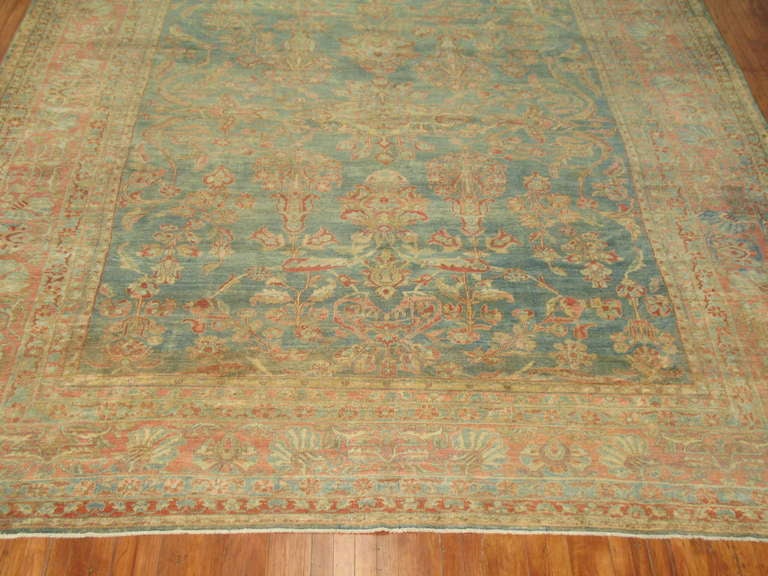 An early 20th century Persian Sarouk rug. Sea foam background with a terracotta border.