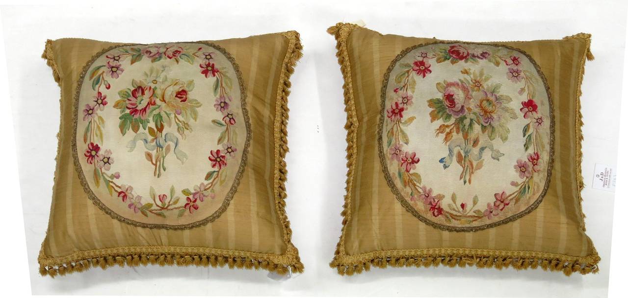 An exquisite set of 18th century French Aubusson pillows woven in silk and wool each measuring 1'10'' x 1'11''. Both have been sewn shut with what we think are down fill inserts.