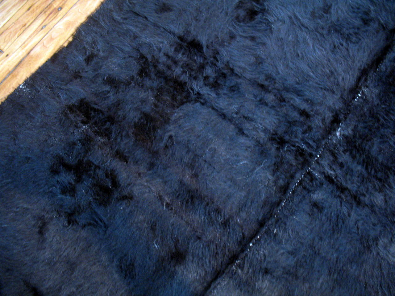 A solid black handwoven Turkish mohair rug that can be used as a floor covering or a blanket or even a wall hanging. All natural dyed woven in panels on a narrow loom.