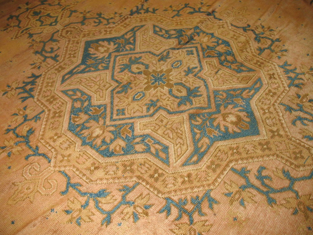 Ein riesiger antiker türkischer Oushak-Teppich mit einem sehr interessanten türkisfarbenen Farbton mit einem karamellfarbenen Medaillon in der Mitte auf lachsfarbenem Grund. In ziemlich gutem Zustand, was für einen Teppich dieser Größe und aus