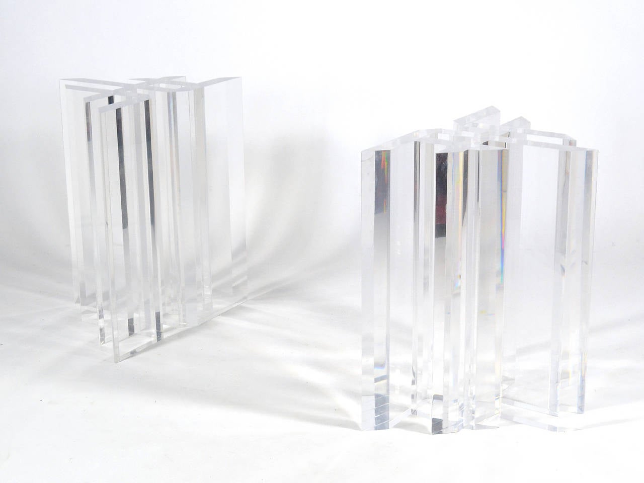 This pair of dynamic John Mascheroni table pedestals have a complex geometric design executed in thick Lucite. The two bases can be arranged in different configurations and are capable of supporting a very large glass top for a substantial dining
