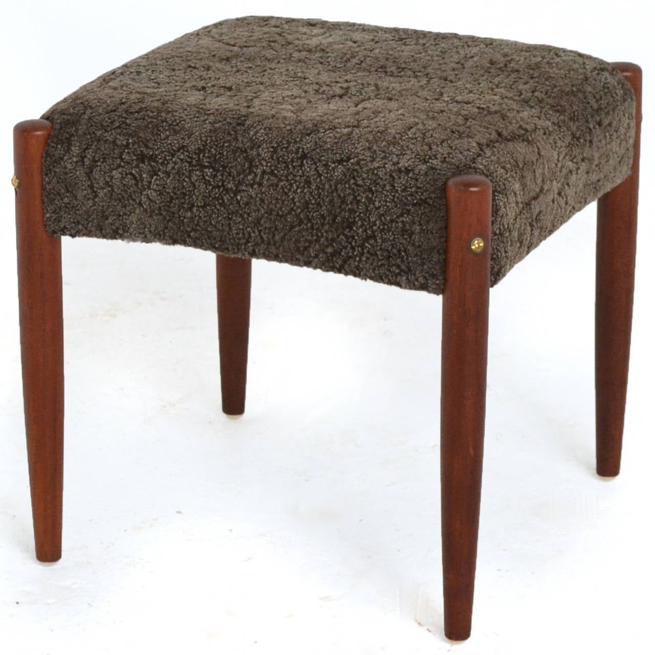This Danish modern stool features teak legs and upholstery of gray sheepskin for a rich and comfortable seat.