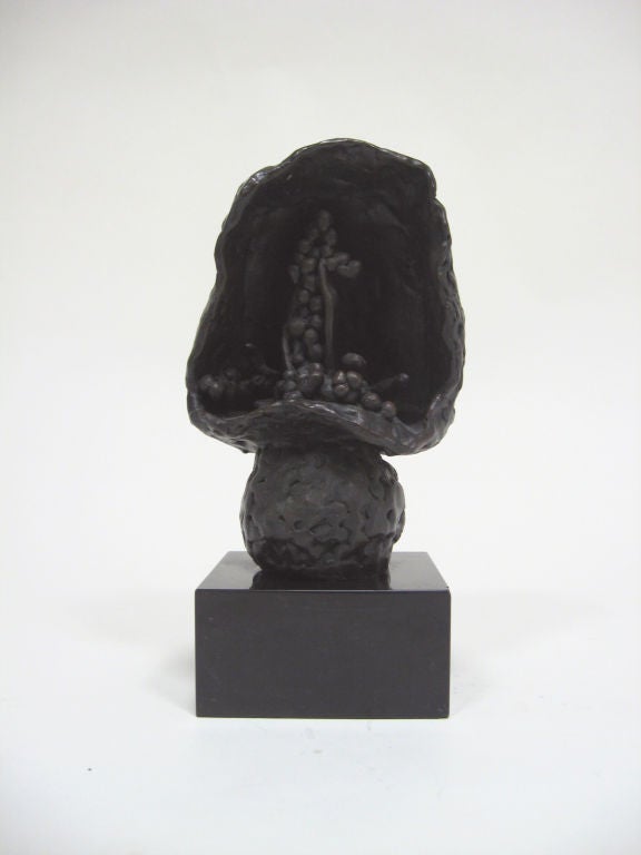 This compelling biomorphic abstraction by Roszi Tevan is a very provocative form. Dark and mysterious, the piece seems alive despite the dense materiality. Inside a large mushroom shape small shapes appear to undulate and multiply, speaking to the