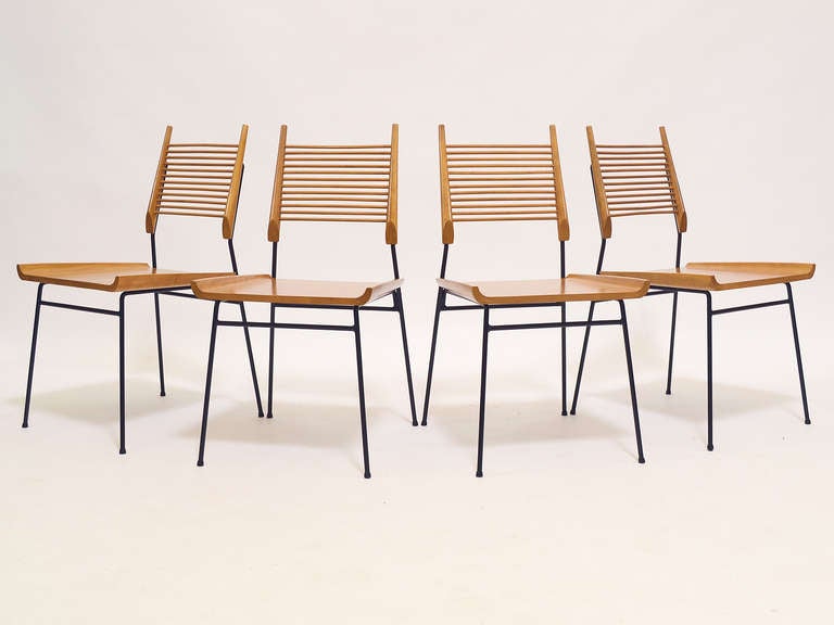 Designed in 1953 as part of the Planner Group, these chairs are remarkably progressive and almost startling in their stark linear design. A sculpted seat and a back comprised of wooden dowels supported by a black iron frame speak to design trends of