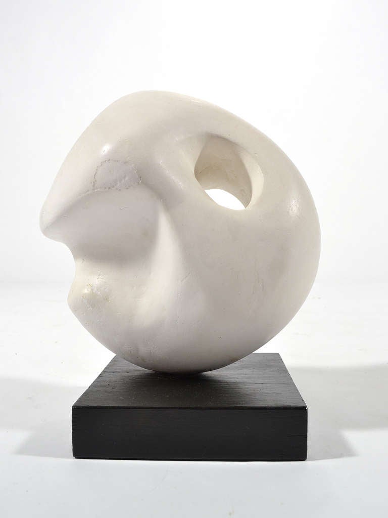 This small biomorphic abstraction in plaster reminds us of the work of Henry Moore and Jean Arp. The pierced form has a pleasing shape, scale and surface texture. It is mounted on a black painted wood base.