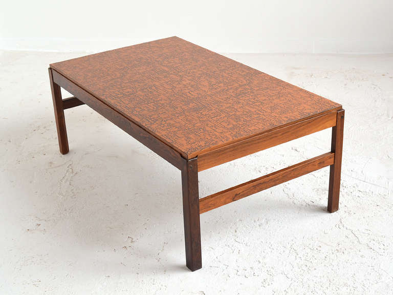 This compelling and uncommon large coffee table has a very subtle form and construction details, but very striking rosewood base supporting a top of textured copper.
