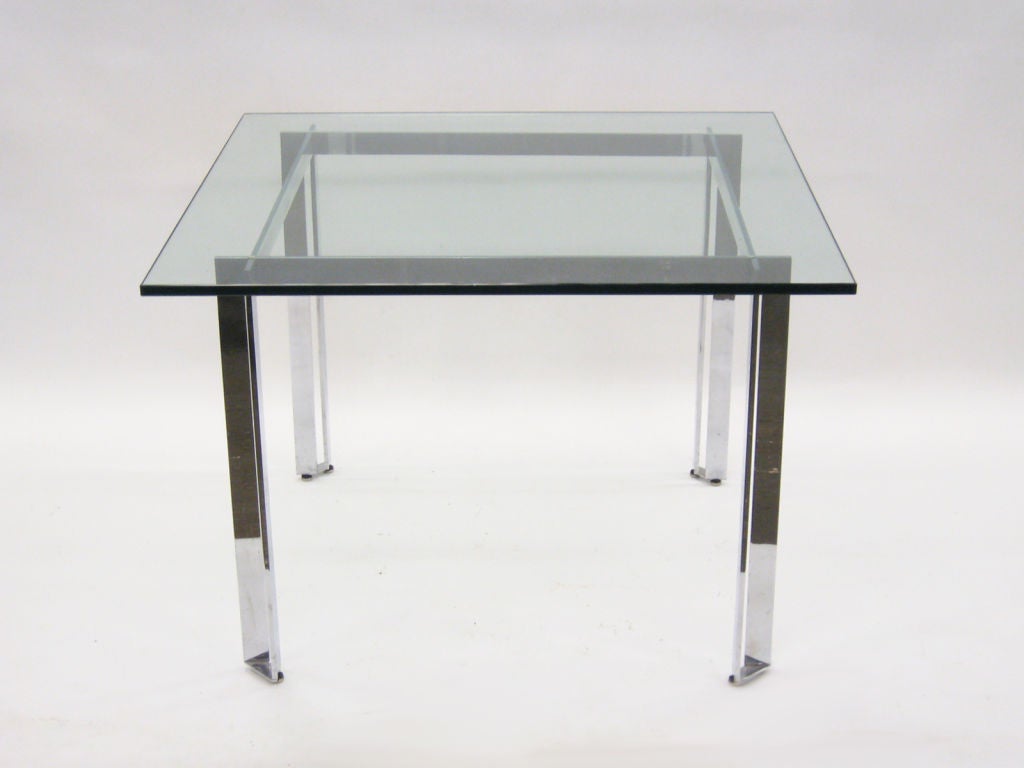 This striking dining table designed by James Howell has great lines and a nice scale with a 42” square glass top. The chromed steel base references Kjaerholm’s designs with the cross-lap at the corners.