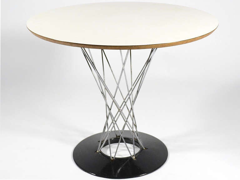 Taking inspiration from a Japanese washbasin, in 1954 Noguchi designed a rocking stool with a base of wire rods. The design was adapted to create both a side table and a dining table. This nice early example has a 36