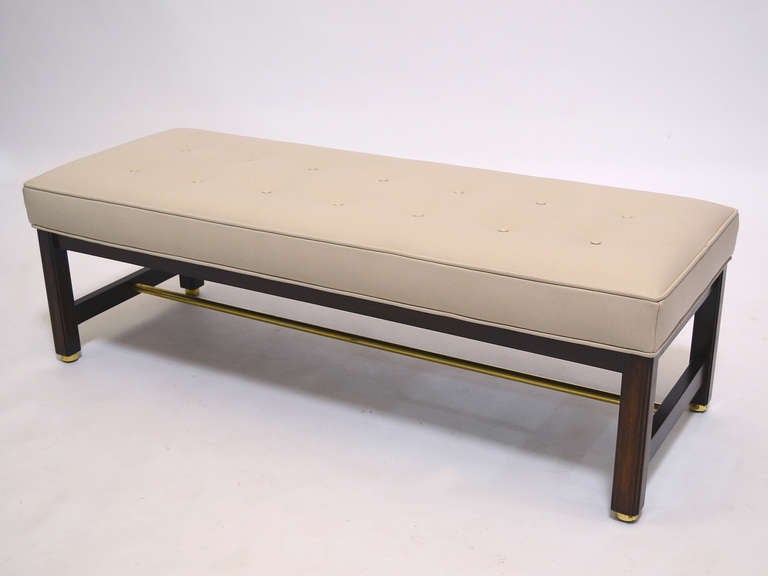 A stunning piece that is also wonderfully versatile, this upholstered bench by Edward Wormley features his characteristic balance, restraint, and attention to detail. The mahogany base has beautifully refined fluting to the edges, a round brass