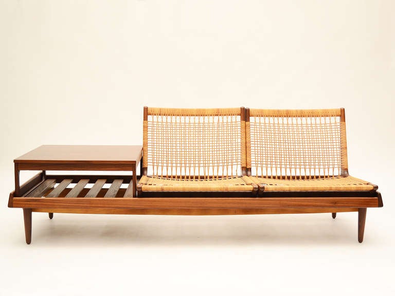 A verstile design by Hans Olsen, this highly functional sofa has a variety of uses. The table and two seats can be configured in a number of arrangements or they can be used independently. The handsome teak chassis can also function as a daybed with