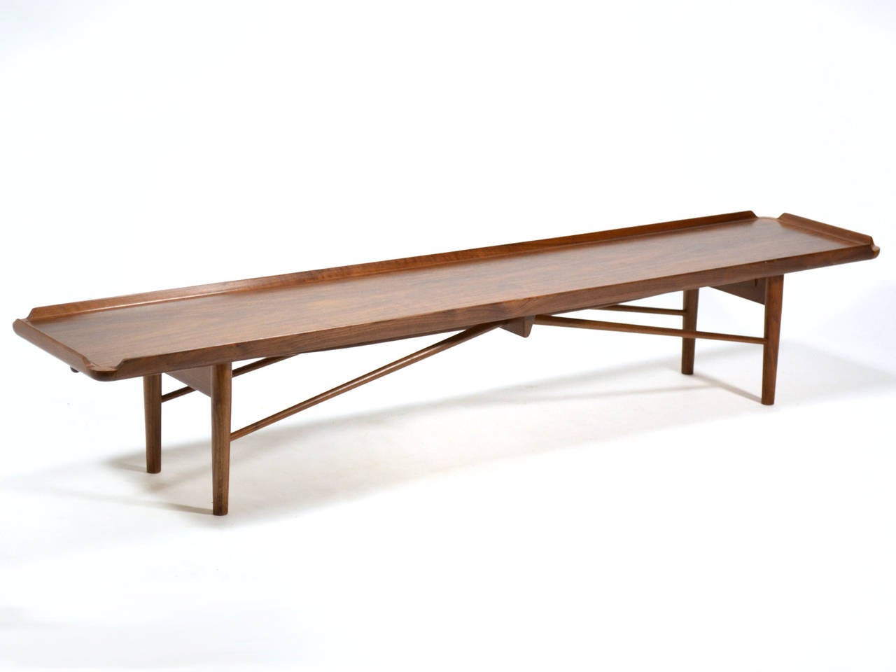 This bench by Finn Juhl was created to serve double duty. It is a long, elegant coffee table, and with the addition of a seat cushion, a comfortable bench. Designed in 1951 for Baker furniture, it predates the more widely seen bench Juhl designed
