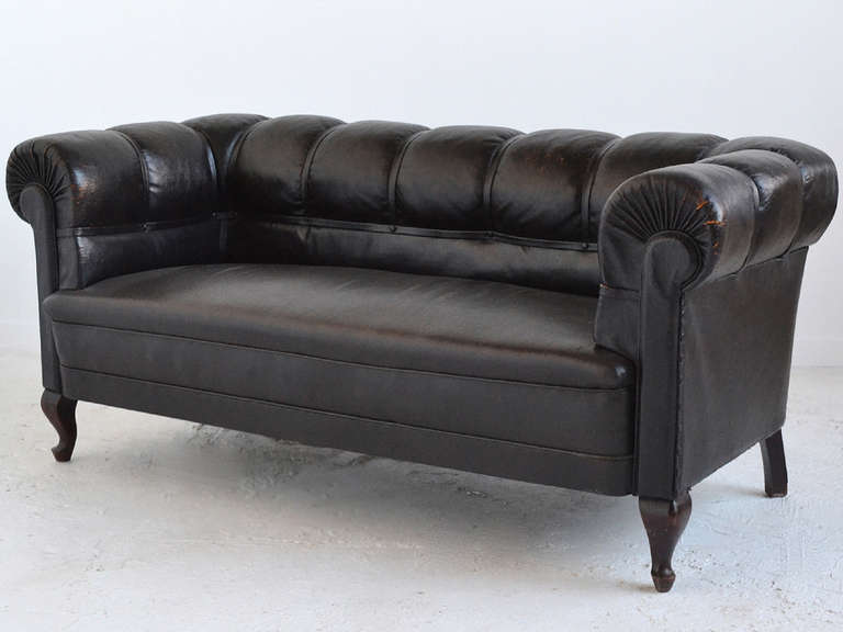 A very striking and powerful piece, this Swedish chesterfield sofa has an incredibly rich patina from age and use. It features several noteworthy details including the large flat upholstery tacks and wonderful sculpted legs.

The leather in the