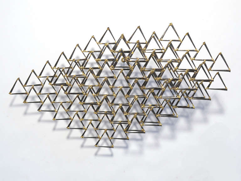 This delightful wall sculpture by Degroot is constructed of square brick nails fused together with bronze. Using repeated and connected triangles, the layered composition becomes very dynamic especially as one moves around and engages with the