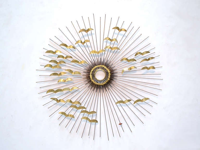 A sunburst in brass peppered with birds in flight, this terrific wall sculpture by DeGroot is a great composition. The sunburst form was a very popular period motif, and this sculpture adds a layer of visual interest and depth with the stylized