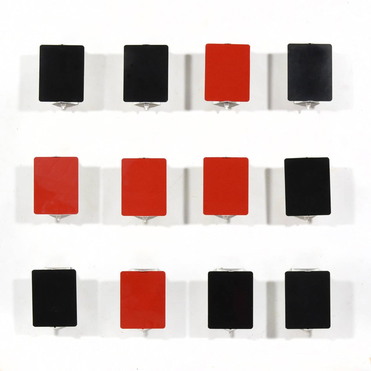 This fantastic set of 12 Perriand wall sconces features five red lamps and seven black. A brilliant minimal design by Perriand, the pivoting shade shields glare and directs the light. The lamps may be used vertically or horizontally and can be