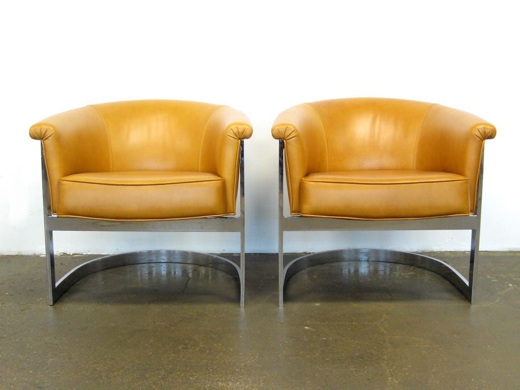 This handsome pair of lounge chairs by Milo Baughman are incredibly well made with heavy steel frames that cradle the cantilevered seats. Newly upholstered in cognac colored leather.