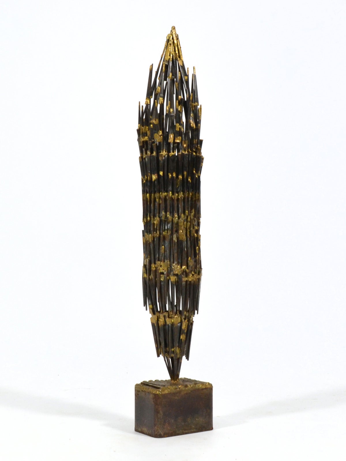 This impressive sculpture of iron and bronze has a obelisque form and terrific presence.