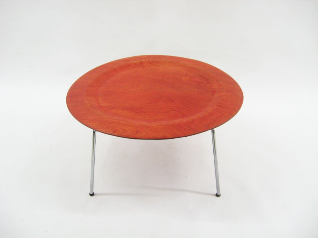 This early Eames CTM (coffee table, metal legs) is uncommon and even more so with the red aniline dye finish on the top. Like the LCM lounge chair, the metal base contrasts nicely with the wood top while the slender legs make the top really appear