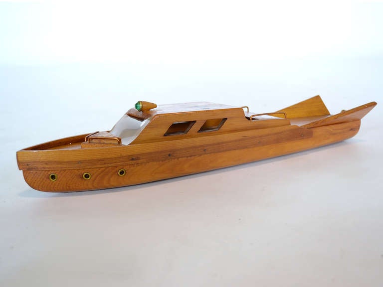 This wonderful vintage handmade model boat dates from the 1950s and features dramatic tail fins. We have searched for a comparable motorboat design wondering if the craftsman who made this model was copying their beloved watercraft, but could not