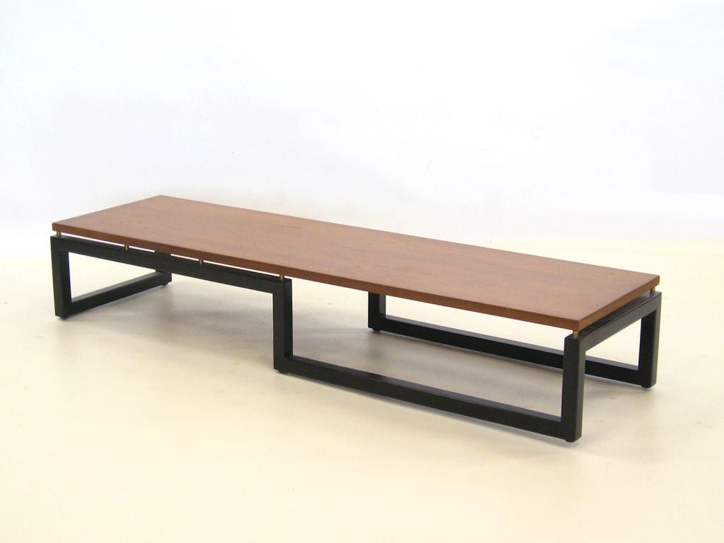 Designed by Paul Tuttle, Michael Taylor, and Winsor White as part of Baker's New World group c.1953, this long low table has an elegant architectural base and a floating top. It was conceived as a 
