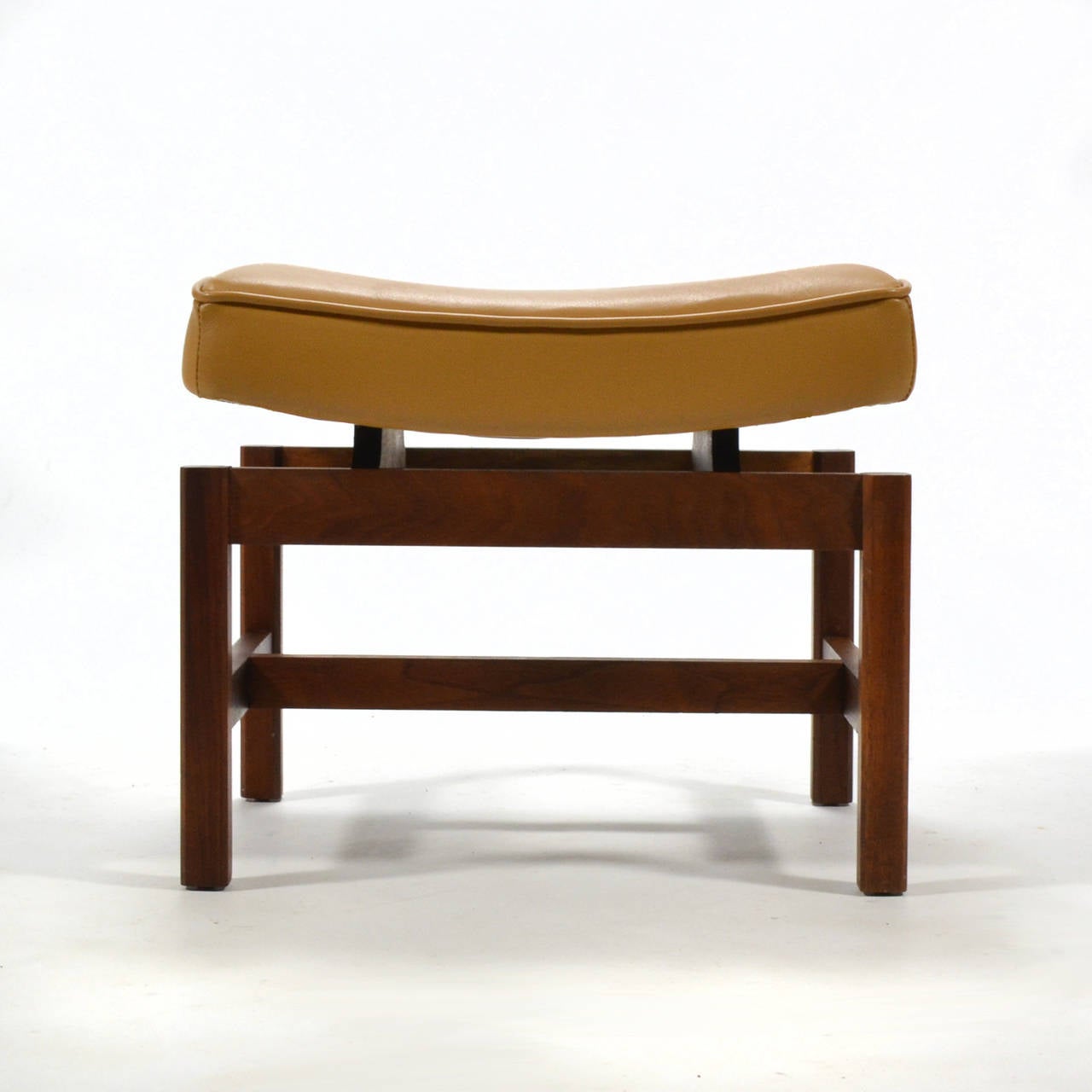 A bench, a stool, an ottoman... this delightful little piece by Jens Risom serves many functions. With a base of rich walnut and a top upholstered in caramel leather, it is lovely and useful. The 