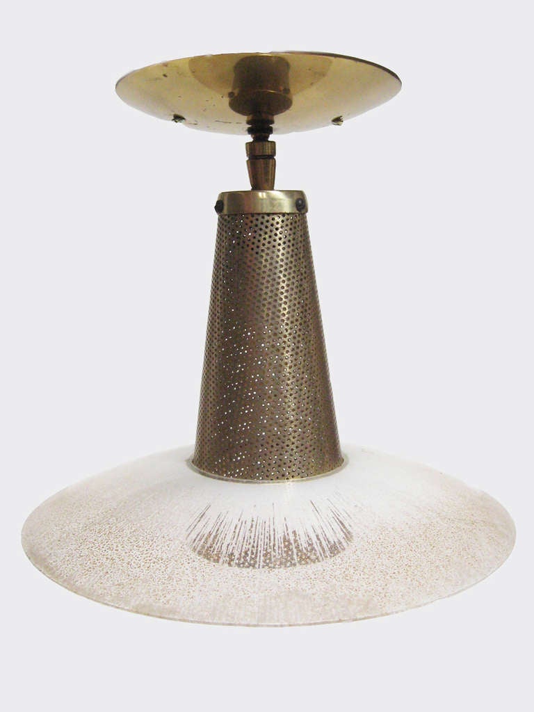 This nice Lightolier ceiling light is a great period example. The perforated conical housing supports a glass diffuser that varies from white to clear/ brass flecked. The fixture is perfect for smaller spaces such as entryways and offers not only