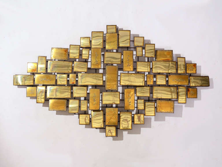 This large, dramatic brass wall sculpture by William Bowie is an abstract composition of squares and rectangles with torch cut edges and applied patina giving the shapes a range of tones and surface interest. 

Reminiscent of designs by Harry