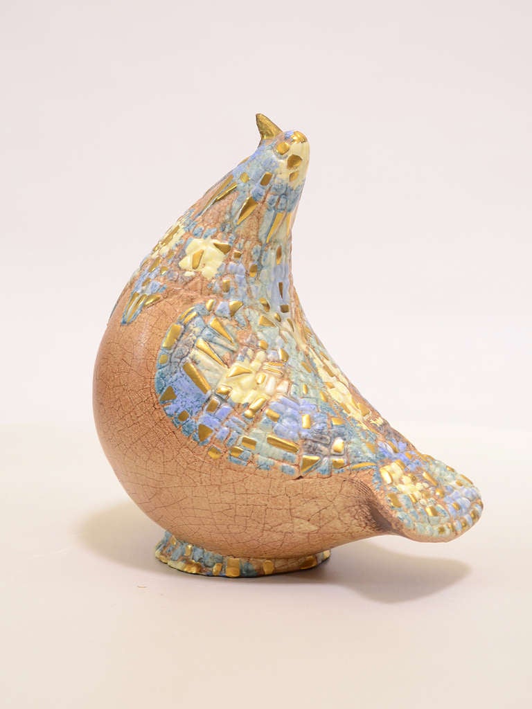 This delightfully simple,  styilzed bird form becomes a shaped canvas for Sascha Brastoff and his signature elegantly decorated surfaces. The exuberant artist/ designer created a complex patchwork of blues and golds over the sienna raku base glaze.
