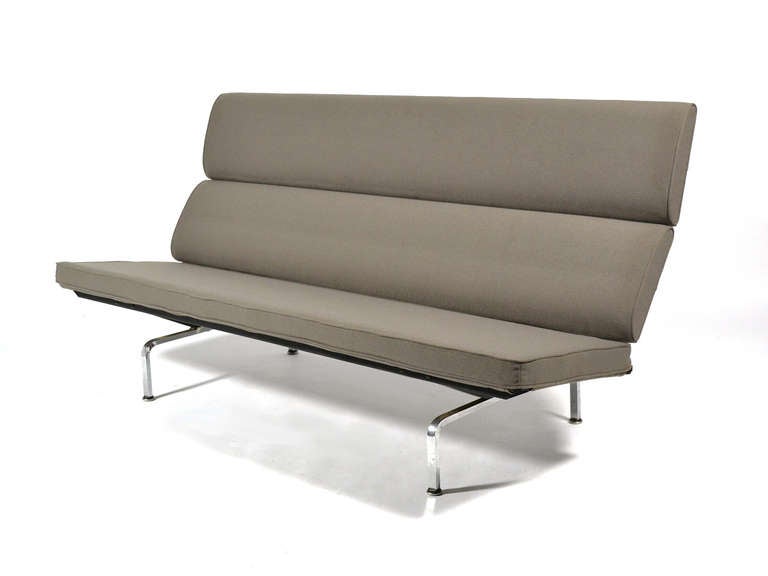 The sofa compact designed by Charles and Ray Eames developed from the built-in sofa they created for their groundbreaking steel home. It features a steel frame which is supported by demountable chrome legs and folds down for economical shipping. It
