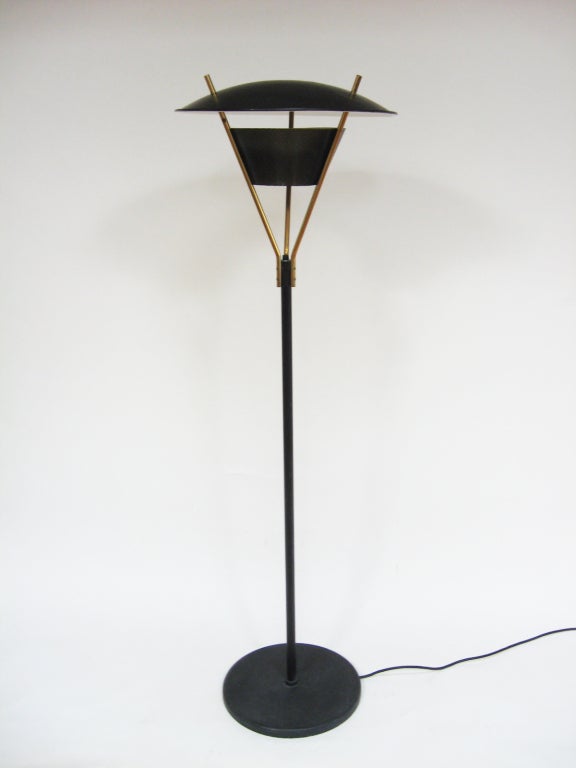 This great floor lamp is architectural with a restrained playfulness, it employs innovative materials (perforated steel) and reflected light for a nice mix of direct and indirect illumination. The switch is at the top of the black stem where it