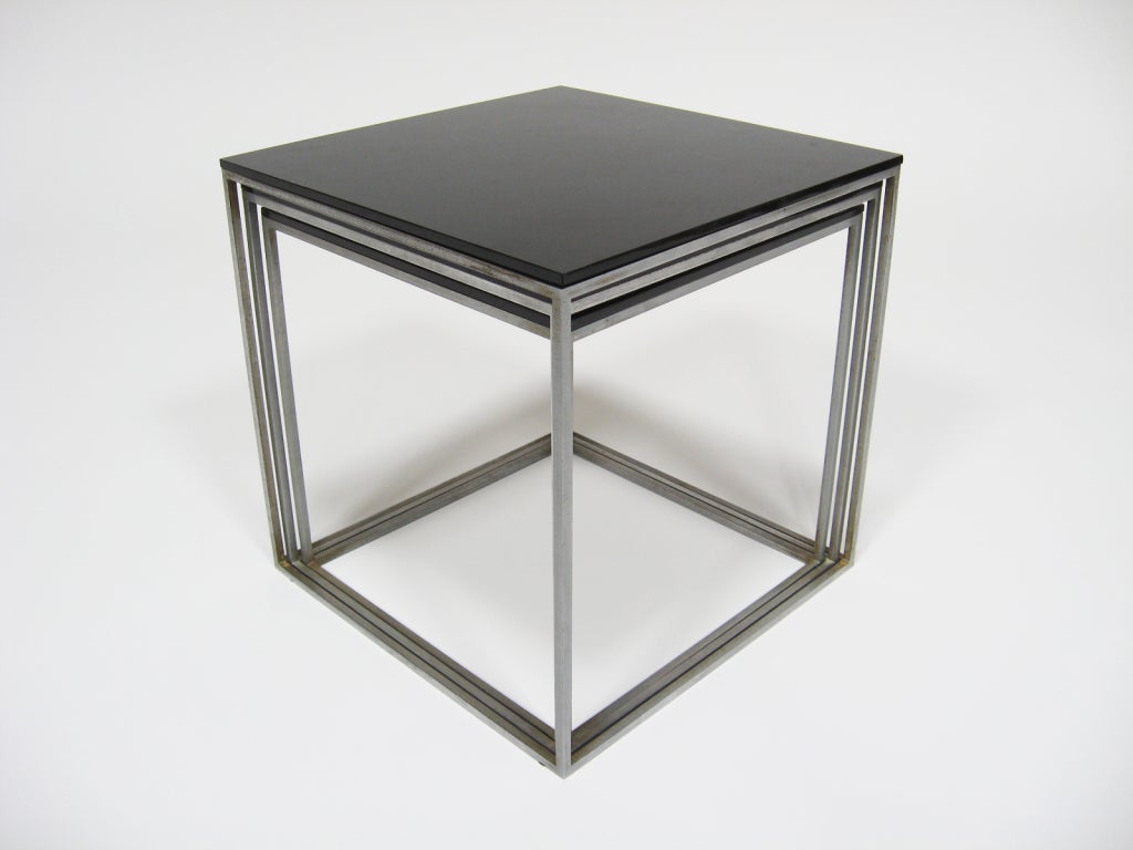 Kjaerholm's minimalism is most evident in the design of his PK 71 nesting tables. Three slender steel frame cubes, which are topped with black acrylic, fit perfectly one inside another. 

They can be used as side or end tables, occasional tables,