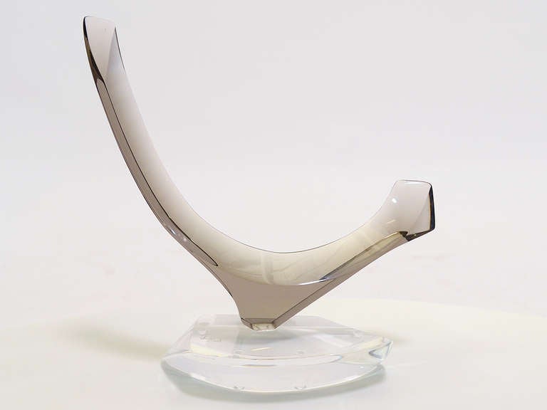 This subtle abstract sculpture is an early work by Hivo Van Teal in clear and smoked acrylic. The elegant curving form has faceted edges which create different shapes within the sculpture as the viewer's vantage point changes. 

The smoked gray