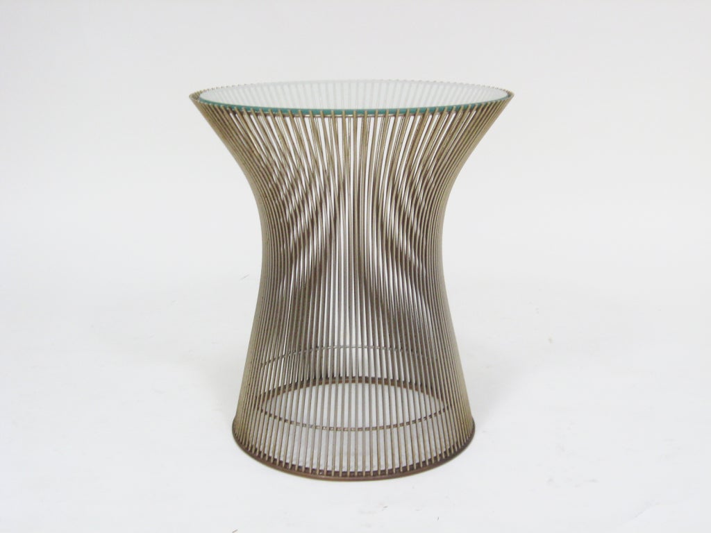 The smallest of the collection of tables Warren Platner designed for Knoll in 1966, this side table nonetheless has great visual presence. The wire rods of the base capture space, create shifting moire patterns, and support the glass top.