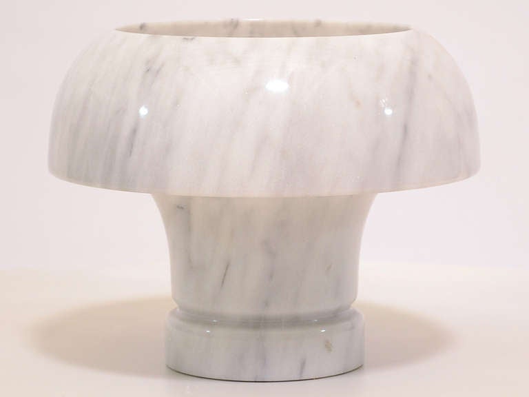 This beautiful lamp by Angelo Mangiarotti is created of a single piece of marble which has been hollowed out and carved into a mushroom form. It has a sublime glow when illuminated. 

There are some fissures and inclusions in the marble (visible