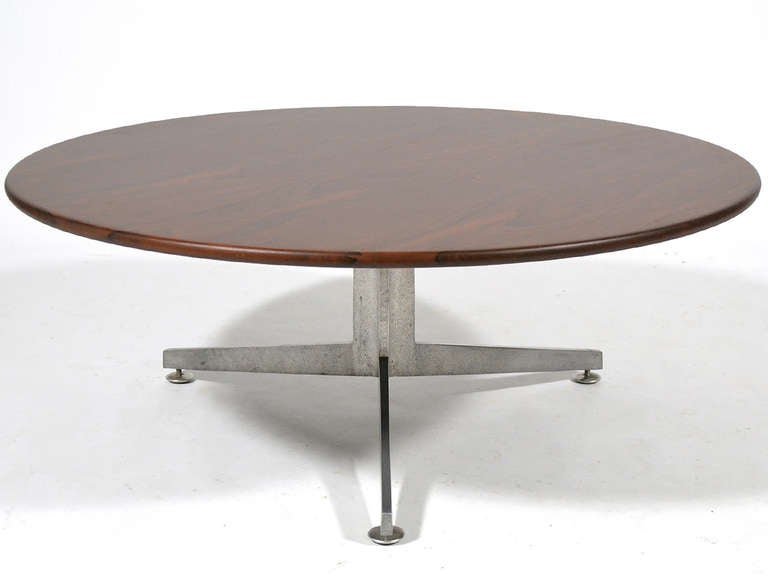 Ward Bennett's expert use of line and proportion are evident in this beautiful coffee table with a three legged aluminum base supporting a rich rosewood top.
