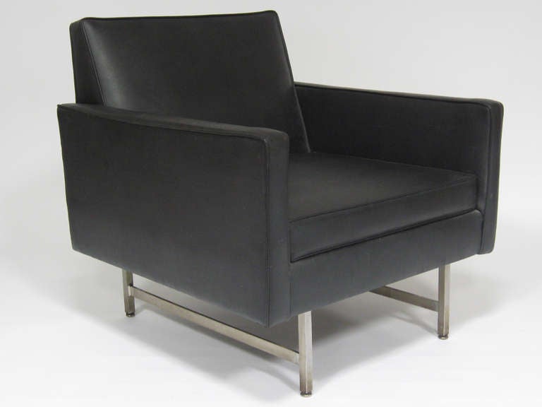A fine example of Paul McCobb's tailored aesthetic and refined sense of proportion, this great lounge chair is in excellent original condition. The upholstery is the original black vinyl and the loose seat cushion is latex foam rubber which has