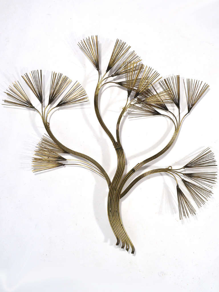 A fluid, organic wall sculpture in the form of a stylized plant form rendered in brass by Jere. Signed and dated.