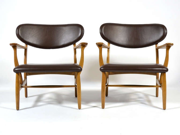 The CH22 by Hans Wegner is a delightful design. Low, wide, light in scale, they are shockingly comfortable. A matched pair is difficult to find, but these are far more rare. The design is typically seen with an exposed wood back and a woven paper