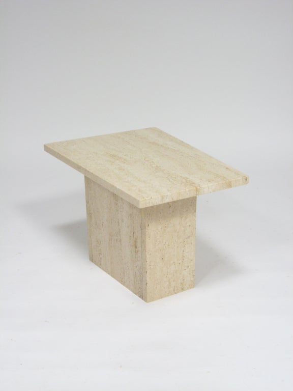This petite side table is fabricated entirely of Italian travertine marble. Both the top and base have a subtle trapezoidal shape and the minimal form is enhanced by the rich texture of the travertine stone.

The top measures 12