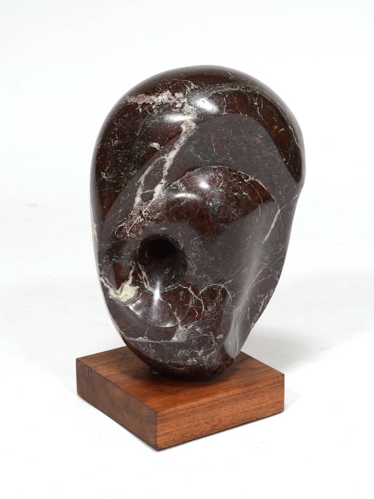 This wonderful marble sculpture recalls the abstract work of Barbara Hepworth with its simple shape, curvy lines, and pierced mass. It has a great rhythm with undulating forms, and the substantial weight balances on the wood base at a fine point.