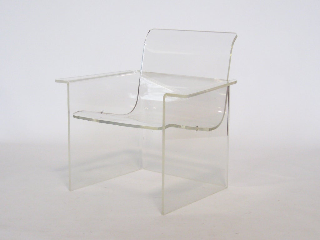 This terrific lucite chair is a compelling piece that uses the most minimal of forms and materials to create a design that is elegant as well as playful. With two interlocking pieces of acrylic, this form defines the chair in its simplest terms.